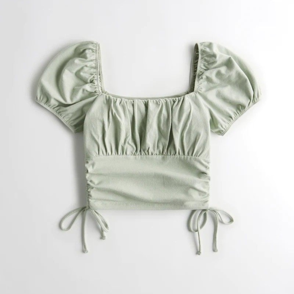 A cute green crop top with puffy sleeves and strings